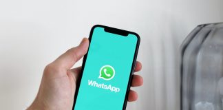 person-holding-iPhone-in-WhatsApp-logo