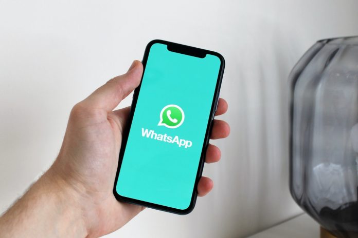person-holding-iPhone-in-WhatsApp-logo